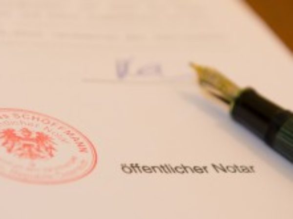 Weißes Papier mit rotem Logostempel von Notariat Schöffmann und schwarzer Schriftzug: öffentlicher Notar